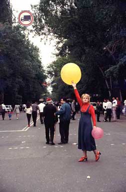 Frau mit roter
                Kleidung und gelbem Ballon