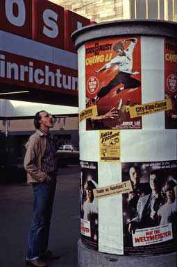 Mann vor
                Litfasssaeule mit Plakat von Kung-Fu-Film